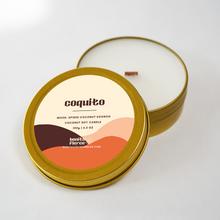 Load image into Gallery viewer, Coquito candle in a gold tin with a white lid on a light gray background