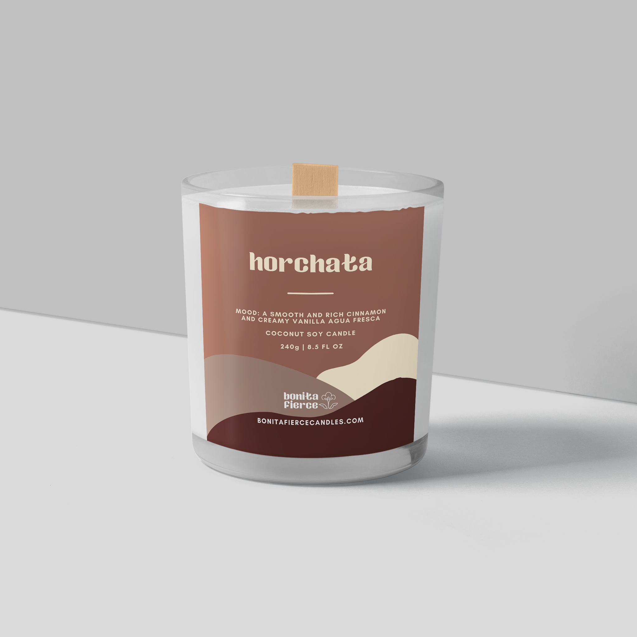 A white candle with a wooden wick and a brown label